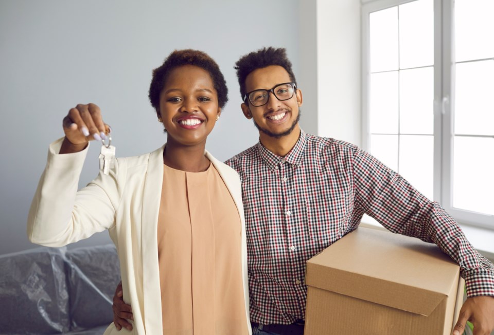 A Collingwood couple hold house keys and moving boxes as first time homebuyers in Ontario